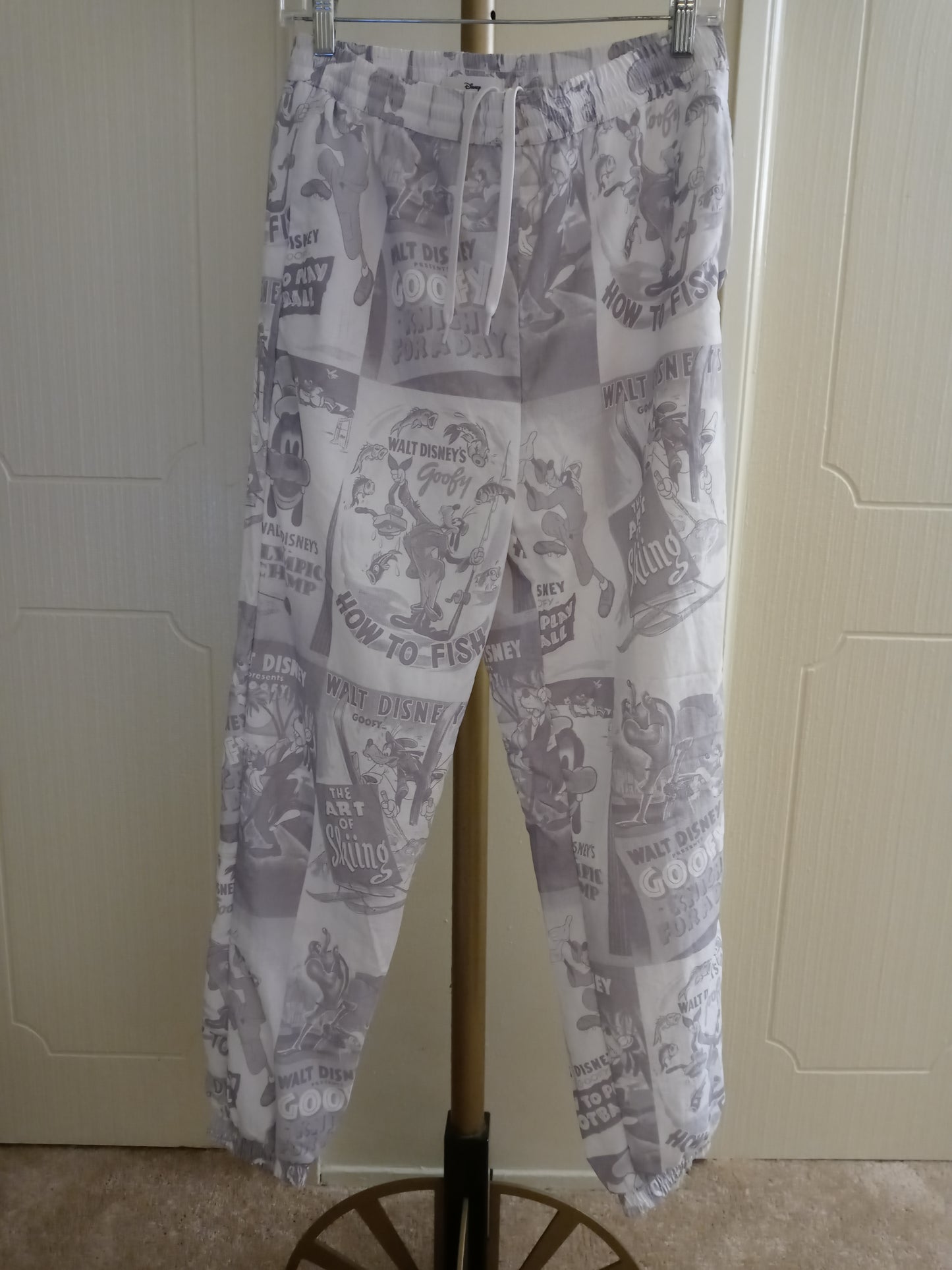 Disney D23 Expo 2022 Exclusive Goofy 90th Anniversary Track Pants Pre Owned - Good Condition Draw String Tie Up Front 2 Zipper Side Pockets 1 Zipper Back Pocket Unisex Size - Small Grey & White
